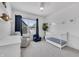 Bright Bedroom features a white crib, comfortable seating, modern ceiling fan, and natural light from the window at 1702 Alvord St, Indianapolis, IN 46202