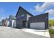 Modern home with a gray exterior, a two-car garage, and a well-maintained yard in a sidewalk neighborhood at 1702 Alvord St, Indianapolis, IN 46202
