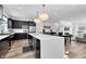 Modern kitchen with stainless steel appliances, dark cabinets, and a large white center island with pendant lighting at 1702 Alvord St, Indianapolis, IN 46202