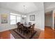 Dining room with a large table, hardwood floors, tray ceiling, and a chandelier for a formal dining experience at 17027 Rainier Cir, Westfield, IN 46062