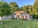 Charming single-story home with a well-manicured lawn, colorful flower beds, and mature trees under a sunny blue sky at 17027 Rainier Cir, Westfield, IN 46062