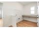 Bright laundry room with wood-look flooring, a window, counter space and shelving at 19522 Wood Farm Pl, Westfield, IN 46074