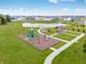 Aerial view of a community park with a pond, playground, covered picnic area, and walking paths at 279 Commodore Dr, Pittsboro, IN 46167