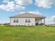 Rear exterior view of a home featuring a well-manicured lawn and a charming covered patio area at 30 Benfield Dr, Whiteland, IN 46184