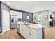 Open kitchen with white cabinets, island with sink, and view into the dining area at 30 Benfield Dr, Whiteland, IN 46184