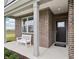 Cozy front porch with brick accents, white bench, and stylish entryway at 30 Benfield Dr, Whiteland, IN 46184