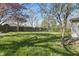 A spacious backyard with a lush lawn, mature trees, and a classic wooden fence, perfect for outdoor enjoyment at 303 W 7Th St, Lapel, IN 46051