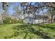 A spacious backyard with a lush lawn, mature trees, and a detached garage, perfect for outdoor enjoyment at 303 W 7Th St, Lapel, IN 46051