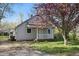 Charming home featuring a cozy front porch and lush flowering tree in the front yard at 303 W 7Th St, Lapel, IN 46051