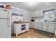 Well-lit kitchen featuring laminate floors, white cabinets, and a moveable kitchen island at 303 W 7Th St, Lapel, IN 46051