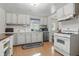 Bright kitchen featuring white cabinetry, laminate floors, and ample counter space at 303 W 7Th St, Lapel, IN 46051