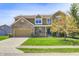 Inviting two-story home with brick accents, attached garage, and well-manicured front lawn and mature tree at 3147 Winings Ln, Carmel, IN 46074