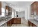 Modern kitchen featuring dark cabinets, granite countertops, and a view into the adjacent living room with fireplace at 3147 Winings Ln, Carmel, IN 46074