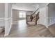 Open-concept living space with hardwood floors, wainscoting, staircase with wood banister, and lots of natural light at 3147 Winings Ln, Carmel, IN 46074