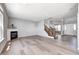 Spacious living room with hardwood floors, a fireplace, staircase with wood banister, and lots of natural light at 3147 Winings Ln, Carmel, IN 46074