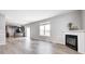 Open-concept living room with a fireplace, hardwood floors, and adjacent kitchen area at 3147 Winings Ln, Carmel, IN 46074