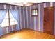 Inviting bedroom with original hardwood floors and vintage striped wallpaper at 3208 Brookside Pkwy N Dr, Indianapolis, IN 46218