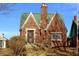 Charming brick home with green roof and detailed ironwork on the front door at 3208 Brookside Pkwy N Dr, Indianapolis, IN 46218