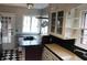 Charming kitchen featuring ample counter space, hanging pot rack, stylish cabinets, and black and white tiled floor at 3208 Brookside Pkwy N Dr, Indianapolis, IN 46218