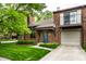 Brick townhome with attached garage, balcony, mature landscaping, and a well-manicured lawn at 354 E Arch St, Indianapolis, IN 46202