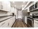 Updated kitchen features stainless steel appliances, white cabinets, and stylish backsplash and flooring at 354 E Arch St, Indianapolis, IN 46202