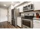 A bright updated kitchen features stainless steel appliances and white cabinets at 354 E Arch St, Indianapolis, IN 46202
