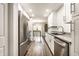Updated kitchen view opens to the dining room beyond, featuring stainless appliances and white cabinets at 354 E Arch St, Indianapolis, IN 46202
