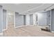 A spacious basement with wood-style flooring leading to other rooms, and newly painted walls and ceilings at 3541 N Linwood Ave, Indianapolis, IN 46218