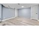 An unfurnished basement space with updated flooring, painted walls, and a door offers a great area to customize at 3541 N Linwood Ave, Indianapolis, IN 46218