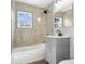A bathroom featuring a shower and bath tub combination, gray vanity, and an overhead light fixture at 3541 N Linwood Ave, Indianapolis, IN 46218