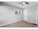 A serene bedroom with neutral walls and carpet flooring has a ceiling fan, a window, and a door at 3541 N Linwood Ave, Indianapolis, IN 46218