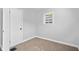 A compact bedroom with a door, window, and neutral walls providing a calm and peaceful atmosphere at 3541 N Linwood Ave, Indianapolis, IN 46218