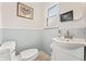 Powder room featuring a white vanity, sink, toilet, and modern decor at 3818 Kessler Boulevard East Dr, Indianapolis, IN 46220