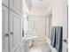Bright bathroom featuring built in cabinets, white fixtures, and a shower over the tub at 3818 Kessler Boulevard East Dr, Indianapolis, IN 46220