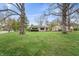Exterior shot of a home featuring a spacious lawn, mature trees, and a blue sky at 3818 Kessler Boulevard East Dr, Indianapolis, IN 46220