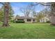 Beautiful exterior home showcasing a well-manicured lawn and mature trees at 3818 Kessler Boulevard East Dr, Indianapolis, IN 46220