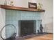 Close-up of fireplace with blue tiles, wooden mantel, and a variety of fireplace tools at 3818 Kessler Boulevard East Dr, Indianapolis, IN 46220