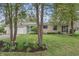Charming stone home featuring a lush, green lawn and a beautiful garden bed at 3818 Kessler Boulevard East Dr, Indianapolis, IN 46220