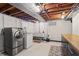 Modern laundry room with stainless steel washer and dryer, utility sink, and stylish cabinet at 3818 Kessler Boulevard East Dr, Indianapolis, IN 46220
