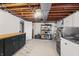 Laundry area with stainless steel washer and dryer, storage cabinets, and open access to the basement at 3818 Kessler Boulevard East Dr, Indianapolis, IN 46220