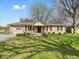 Beautiful brick ranch home with a well-kept lawn, attached garage, and a cozy front porch with chairs at 390 Lakeview Dr, Noblesville, IN 46060
