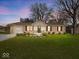Charming brick ranch home features a well-manicured lawn, attached garage, and inviting front porch with seating at 390 Lakeview Dr, Noblesville, IN 46060