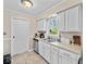 Bright kitchen with white cabinetry, stainless steel dishwasher, and a window above the sink overlooking the backyard at 390 Lakeview Dr, Noblesville, IN 46060