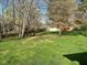 Spacious, green backyard with mature trees and a wooden fence surrounding the property at 3920 Pigeon Creek Ln, Indianapolis, IN 46234