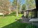 Spacious backyard with a patio area, large trees, and a glimpse into the sunroom at 3920 Pigeon Creek Ln, Indianapolis, IN 46234