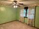 Green bedroom with ceiling fan, carpet flooring, and natural light from the window at 3920 Pigeon Creek Ln, Indianapolis, IN 46234
