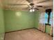 A carpeted bedroom with ceiling fan, a wall with green texture, and floral wallpaper border at 3920 Pigeon Creek Ln, Indianapolis, IN 46234
