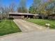 Charming brick home with a well-manicured lawn, a two-car garage and a concrete driveway at 3920 Pigeon Creek Ln, Indianapolis, IN 46234
