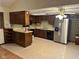 View of the kitchen with dark wood cabinets and stainless steel refrigerator and dishwasher at 3920 Pigeon Creek Ln, Indianapolis, IN 46234