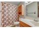 Bathroom with wood cabinet, framed mirror, and patterned curtain in the shower at 4464 Chatham Dr, Brownsburg, IN 46112